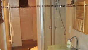 Une salle de bain avec un lavabo en verre, une douche et un porte-serviettes.
