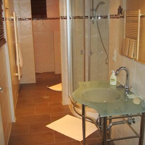 A bathroom with a glass sink, a shower, and a towel rack. - Park Hotel Gastein (Bad Hofgastein)