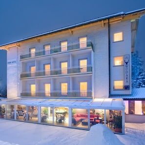 Een hotel met meerdere verdiepingen, een bar/loungeruimte, buiten zitplaatsen en een overdekt terras.