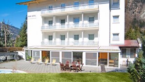 Ein mehrstöckiges Hotel mit Balkonen, einem Pool und Außenplätzen.
