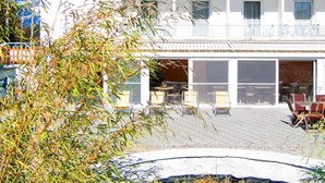Un hôtel à la façade blanche, doté de nombreux balcons et d’un espace piscine.