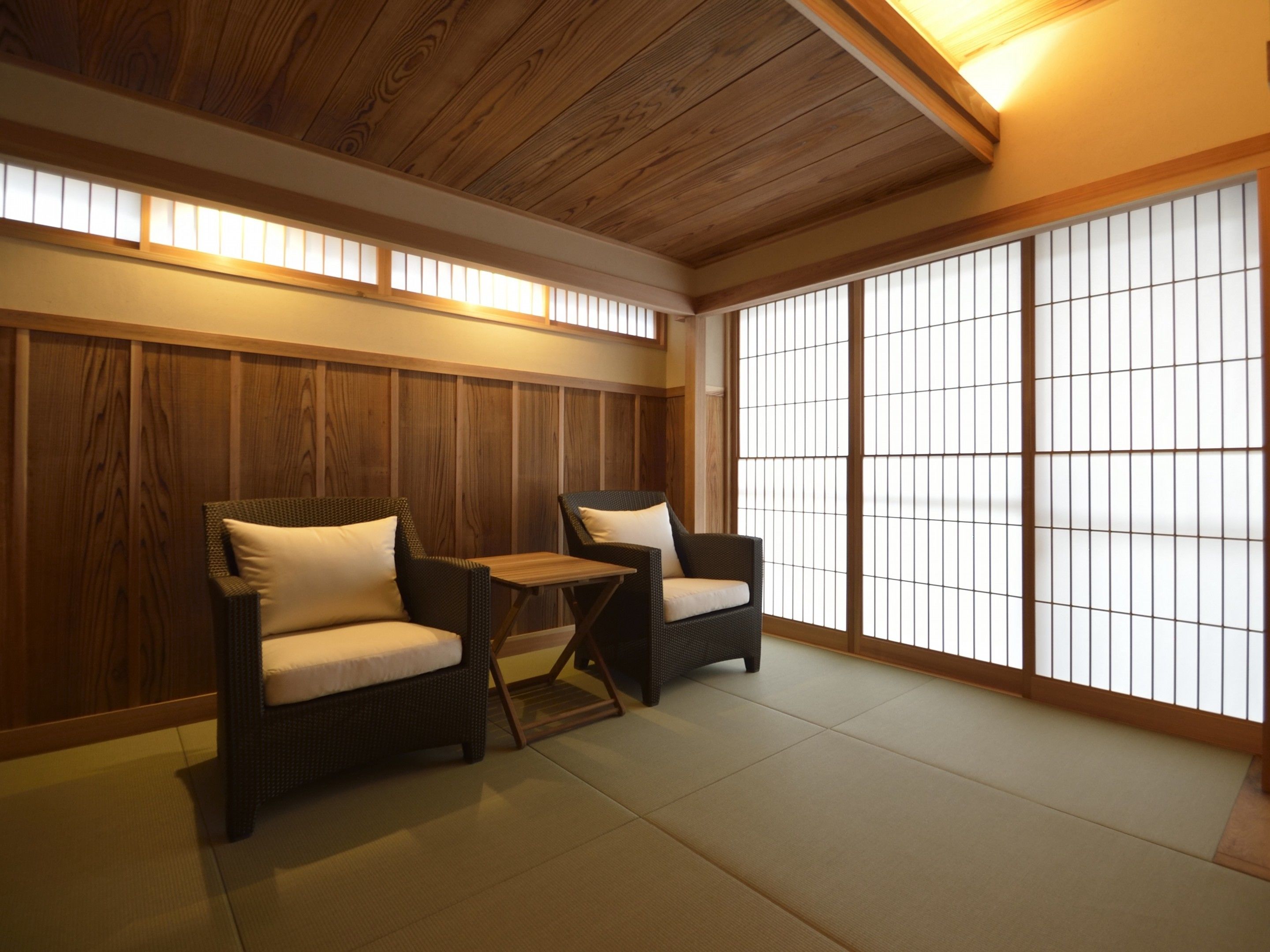 Una habitación japonesa tradicional con suelo de tatami, dos esteras de tatami y una baja mesa de madera.