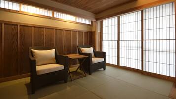 Una habitación japonesa tradicional con suelo de tatami, dos esteras de tatami y una baja mesa de madera.