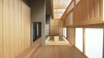 A traditional Japanese-style room with wooden flooring, tatami mats, and sliding doors.
