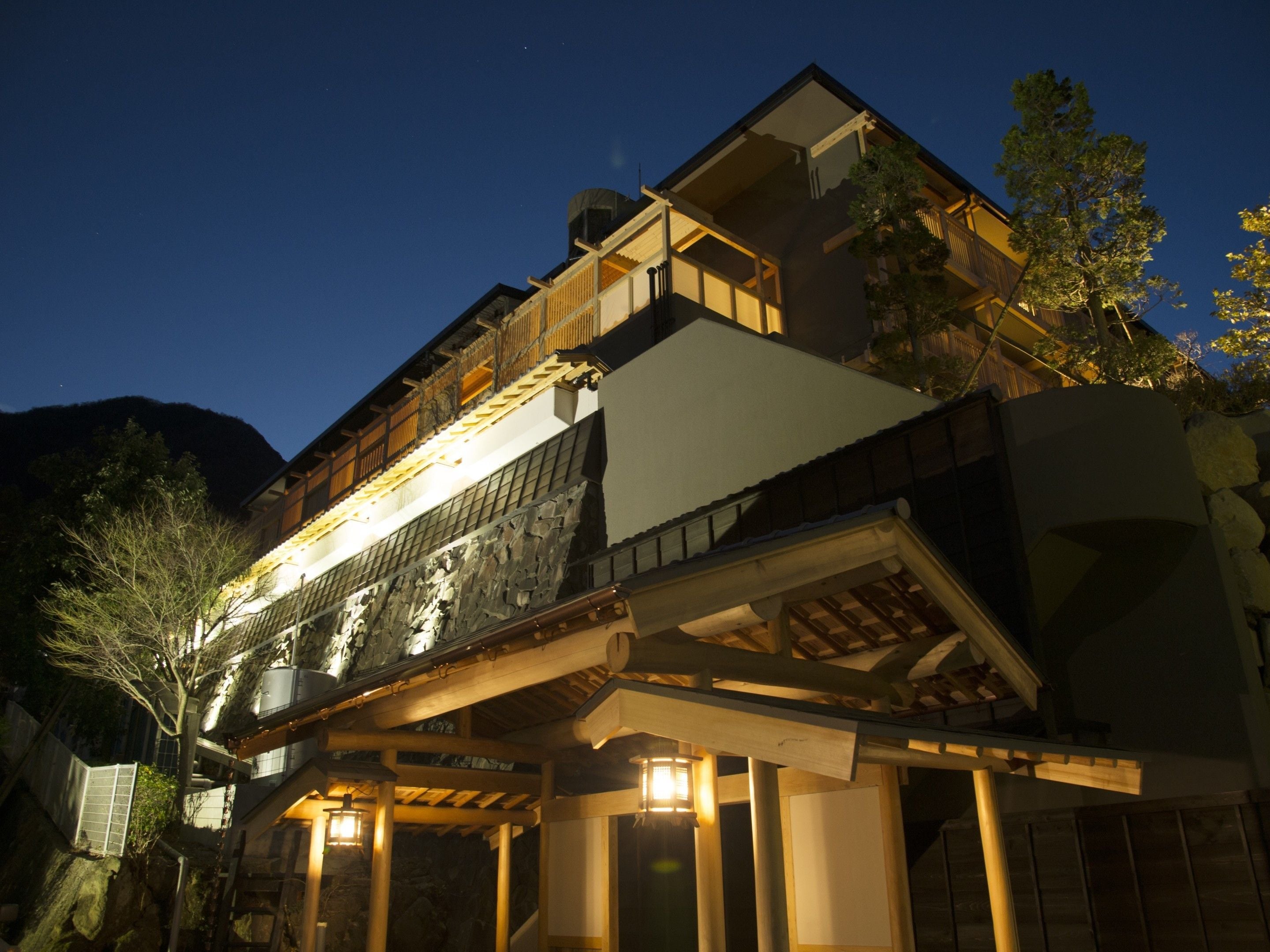 Un edificio de varios pisos con un estilo arquitectónico tradicional, que presenta balcones de madera y fachada de piedra.