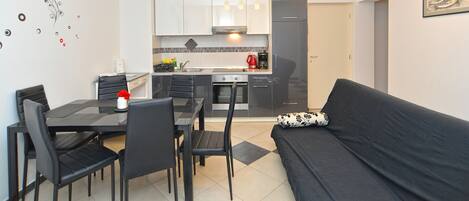A modern apartment with a dining area, kitchen, and living room.
