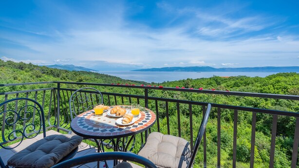 A balcony with a table set for breakfast, overlooking a lush landscape and a body of water. - Apartment Klaudio 294 (Rasa)