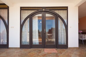 A large, arched door with the number 6 above it, leading to a room with a tiled floor and a small rug in front. - Apartment Milorad 324 (Medulin)