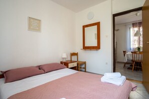A bedroom with a bed, a chair, a desk, and a dining area. - Apartment Jan 325 (Medulin)