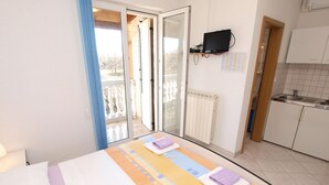 A bedroom with a bed, a bathroom, and a kitchen. - Apartment Mila 395 (Medulin)