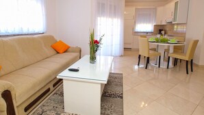 Ein Wohnzimmer mit einer Couch, einem Couchtisch und einem Essbereich mit Stühlen und Tisch.