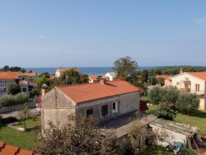 Un pueblo costero con arquitectura mediterránea tradicional, que incluye casas con tejados de tejas rojas y vistas al mar.