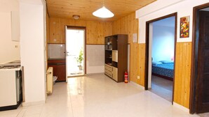 A spacious room with a wooden ceiling, a kitchenette, a dining area, and a bed. - Apartment Aleksander 968 (Fazana)
