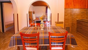 A dining area with a table set for four, wooden chairs, and a vase with flowers. - Apartment Aleksander 968 (Fazana)