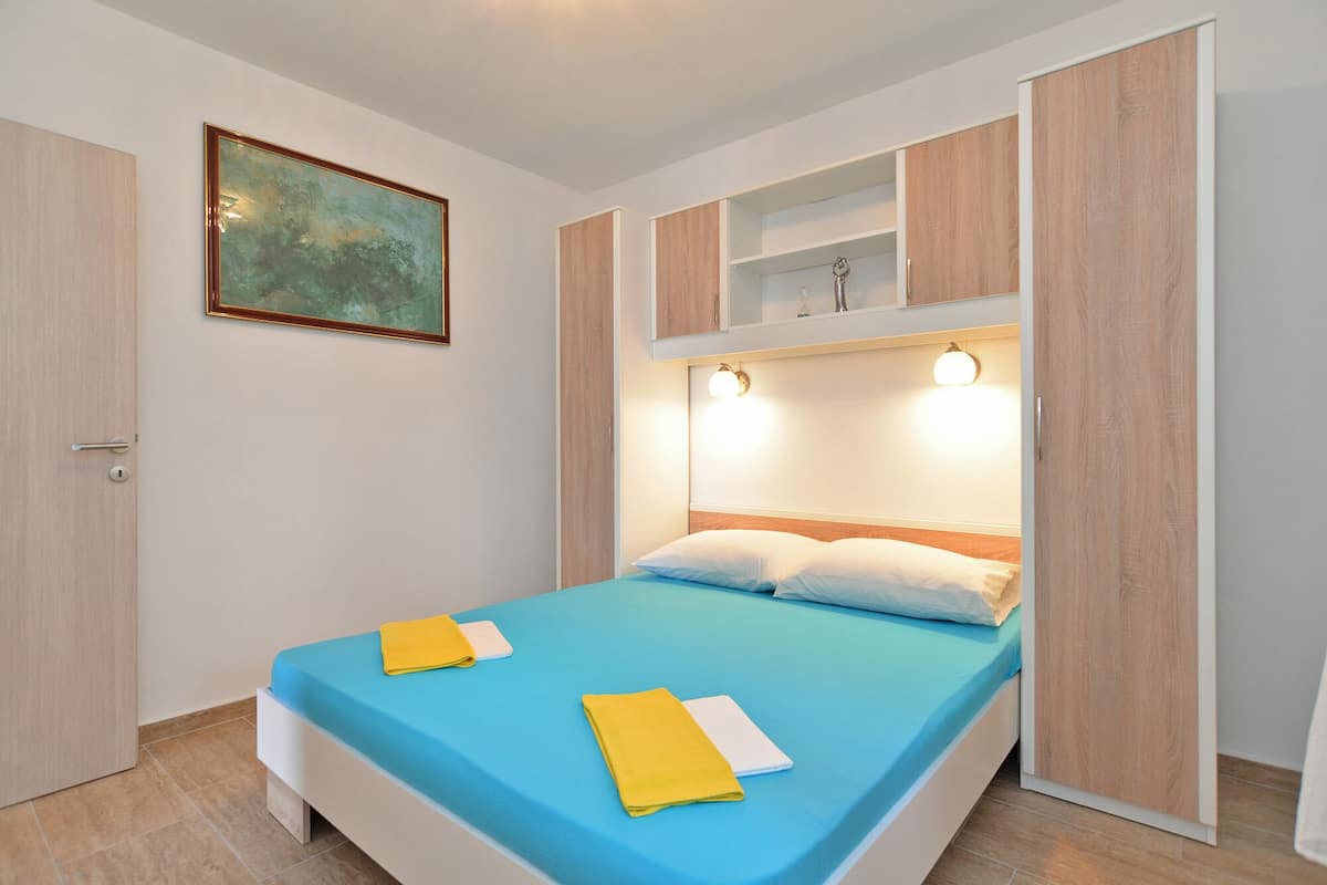 Un dormitorio con cama, un cuadro y armarios empotrados.