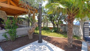 An outdoor patio area with a pergola, a barbecue grill, and various plants. - Apartment Vlado 1405 (Vodnjan)