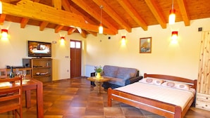 A cozy room with a bed, a sofa, a dining table, and a TV. - Apartment Tatjana 411 (Medulin)