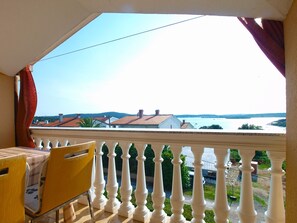 A balcony with a view of a river and houses.