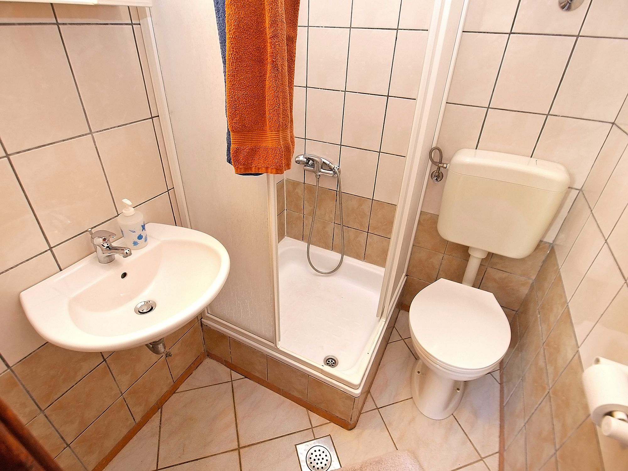 A bathroom with a sink, toilet, and shower.