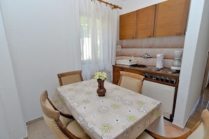 A compact kitchen with wooden cabinets, a white countertop, and a coffee machine. - Apartment Gey 671 (Medulin)