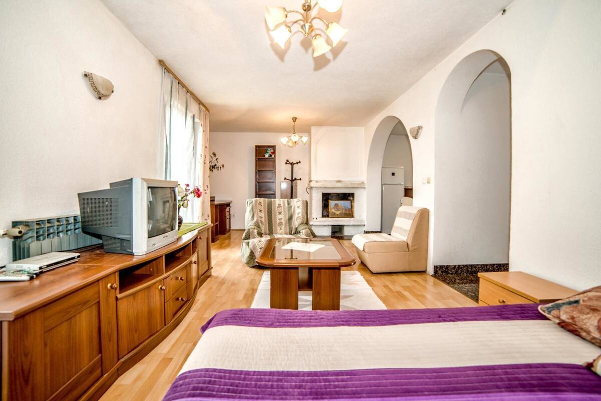 Quarto com cama, televisão, lareira e área de jantar.