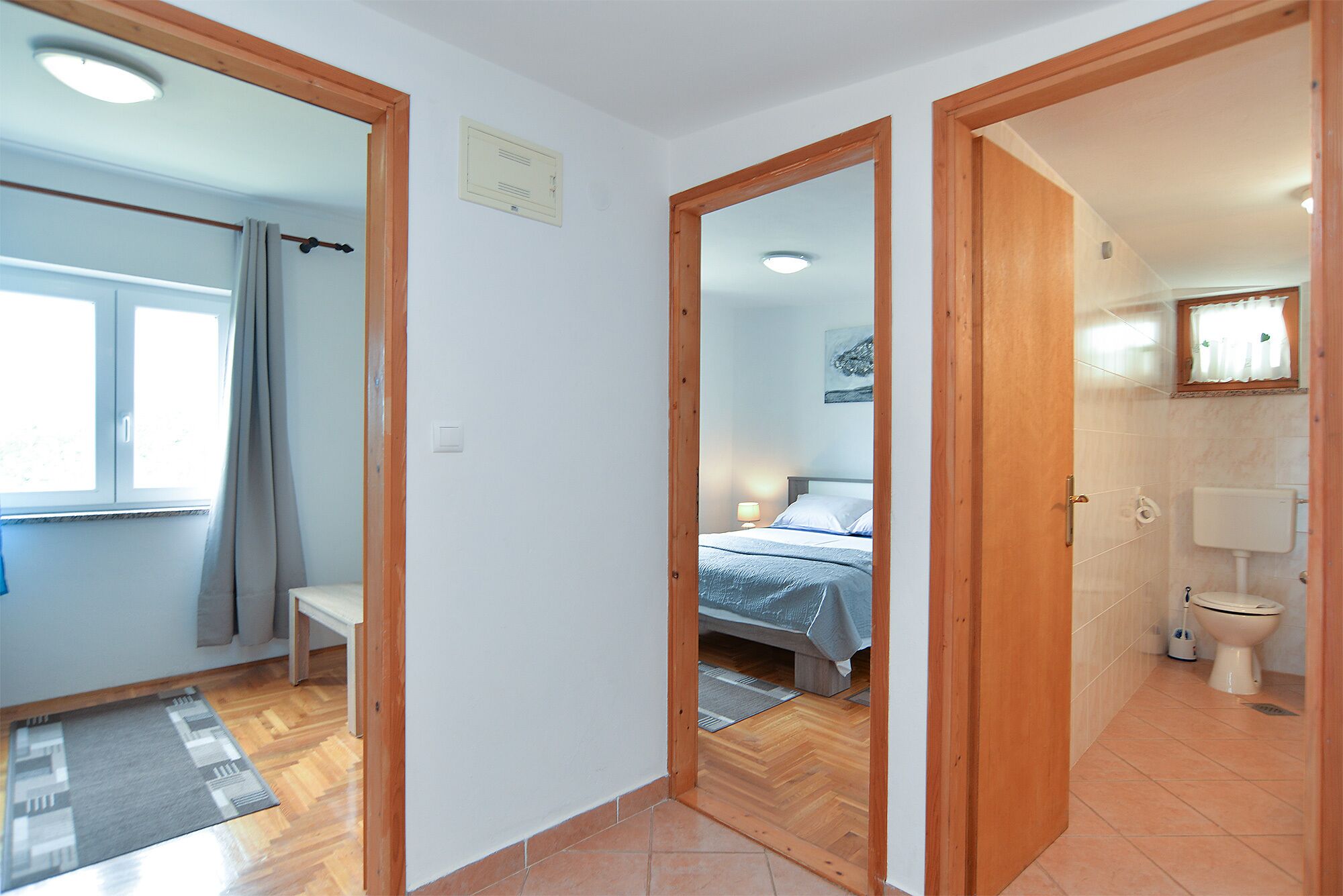 A room with a bed, a bathroom with a toilet, and a shower area.