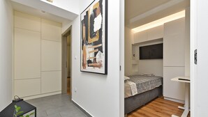 Un dormitorio moderno con cama, mesita de noche y televisor.