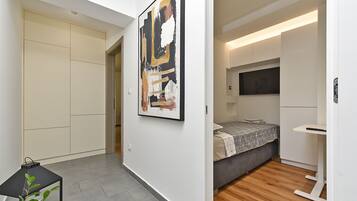 A modern bedroom with a bed, bedside table, and a TV.