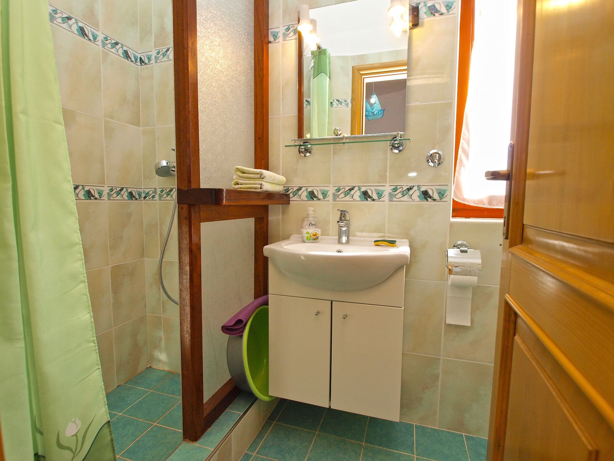 Ein Badezimmer mit Waschbecken, Spiegel und Duschbereich.