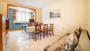 A compact living space with a dining area, kitchenette, and a sofa. - Apartment Lucio 804 (Porec)