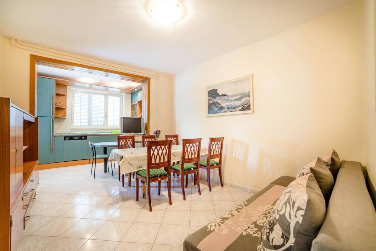 A compact living space with a dining area, kitchenette, and a sofa.