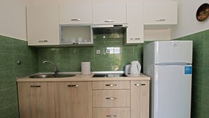 A kitchen with a sink, countertop, cabinets, and a refrigerator. - Apartment Hasima 116 (Medulin)