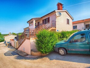A two-story building with a staircase leading to a balcony, a satellite dish, and a parked Citroen car. - Apartments Antonieta 1209 (Medulin)