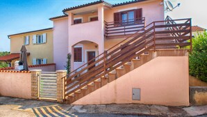 Une maison à deux étages avec un escalier menant à l’étage supérieur, une antenne parabolique et un petit satellite sur le toit.