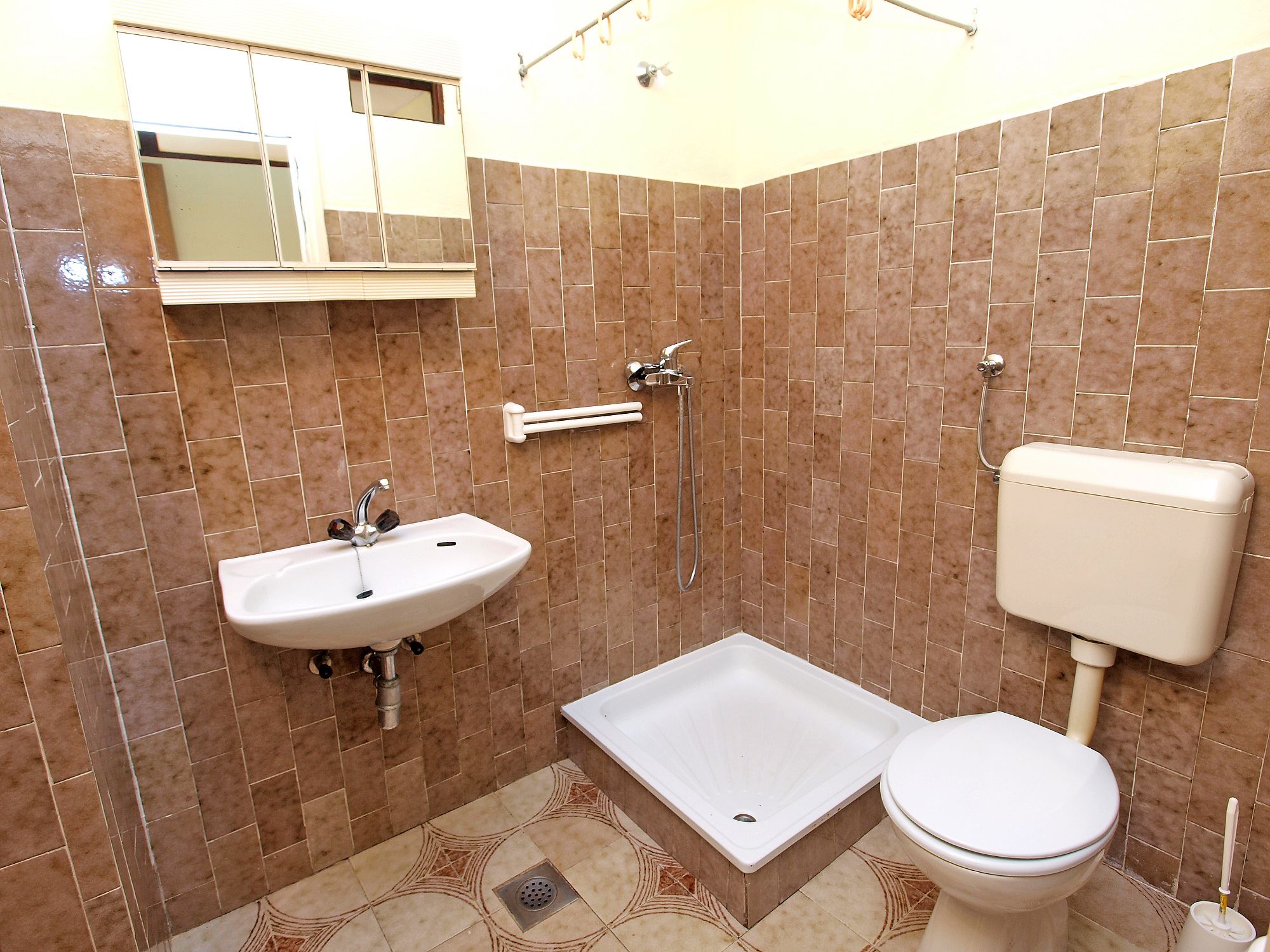 A bathroom with a sink, toilet, and shower.