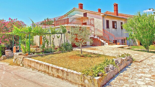 A two-story house with a balcony, a garden with various plants, and a stone pathway leading to the entrance. - Apartments Celine 606 (Medulin)