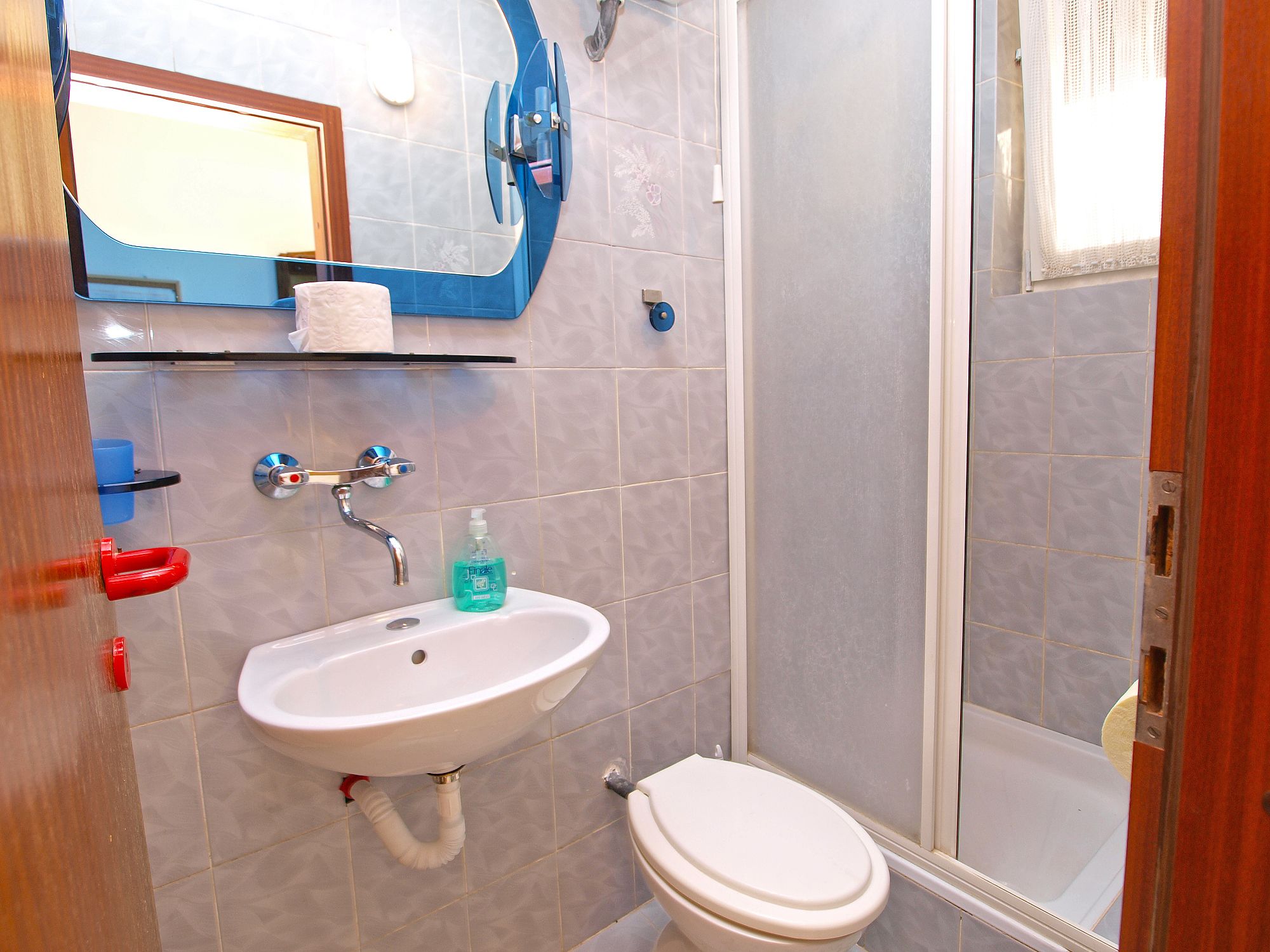 Une salle de bain avec un lavabo, des toilettes et une douche.