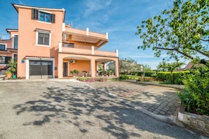 A two-story building with a covered entrance and a landscaped garden.