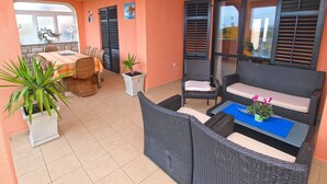A covered patio area with a dining table, chairs, and a seating area with cushions. - Apartments Ivan 65 (Pula)