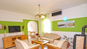 A living room with a TV, sofa, chairs, a coffee table, and a fireplace. - Apartments Ivan 65 (Pula)
