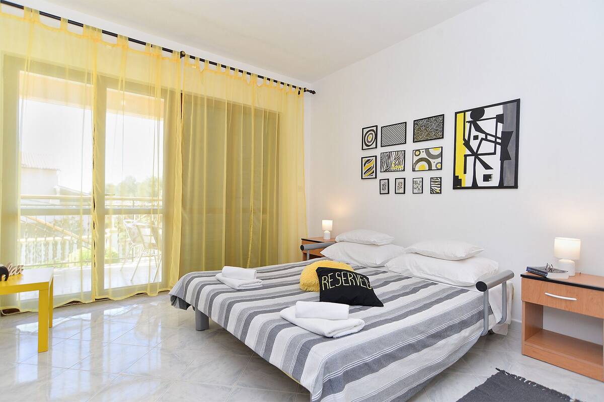 Ein Hotelzimmer mit Bett, Schreibtisch, Stuhl und Bildern an der Wand.