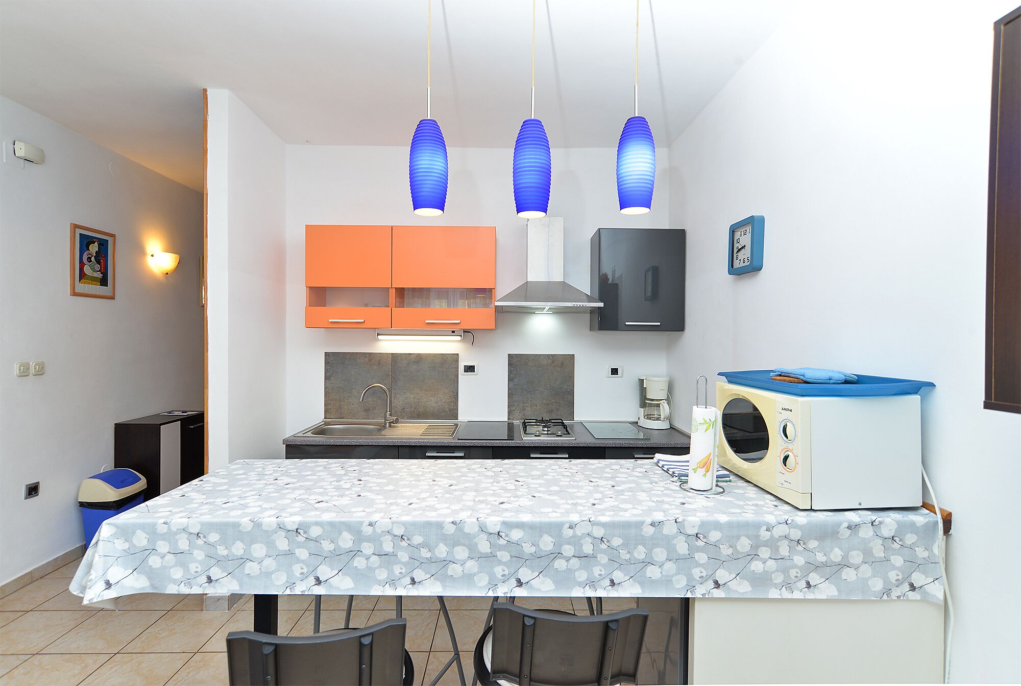 A compact kitchen with a central island, a microwave, and a sink.