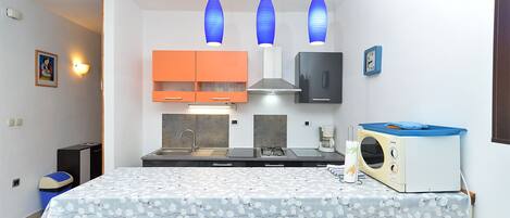 A compact kitchen with a central island, a microwave, and a sink.