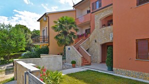 A two-story building with a stone staircase leading to a balcony. - Apartments Mira 295 (Pula)