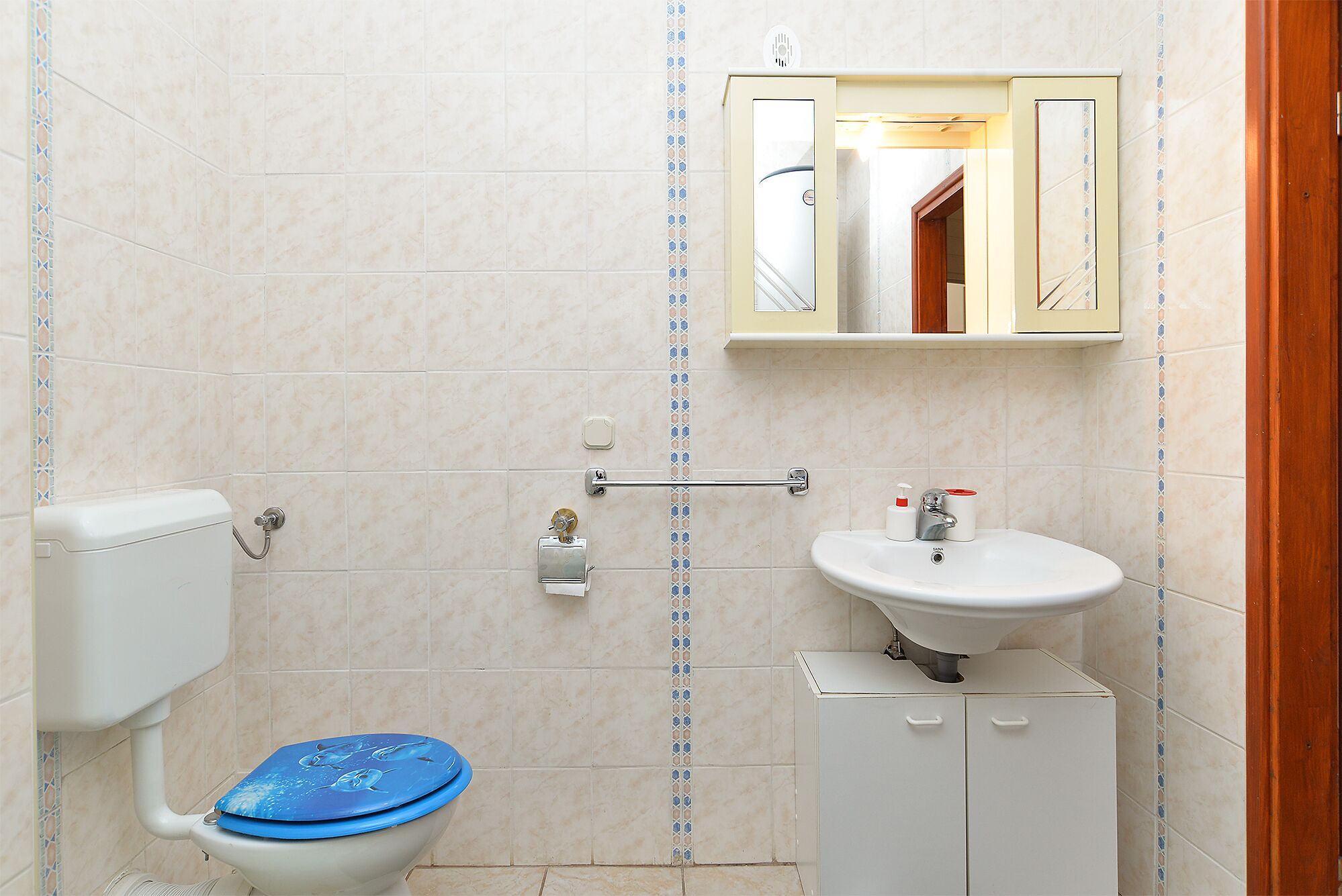 Ein Badezimmer mit Toilette, Waschbecken und Spiegel.