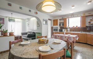 A compact living space with a dining area, kitchen, and a living room.