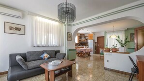 Una sala de estar con sofá, mesa de centro y comedor con mesa y sillas.