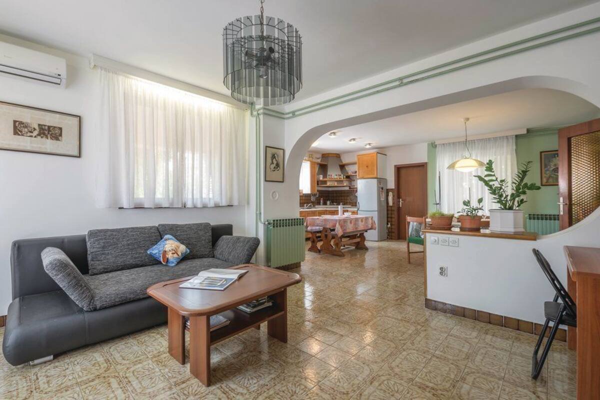 Una sala de estar con sofá, mesa de centro y comedor con mesa y sillas.