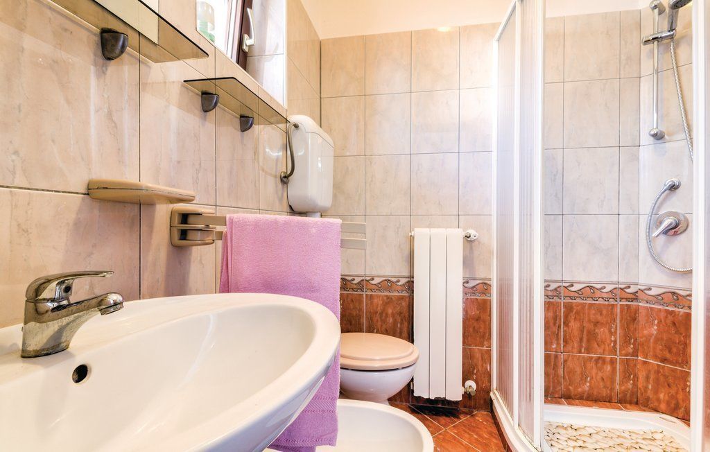 A bathroom with a sink, toilet, and shower.