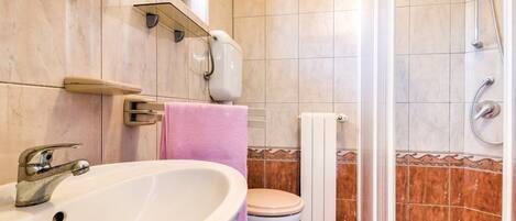 A bathroom with a sink, toilet, and shower.